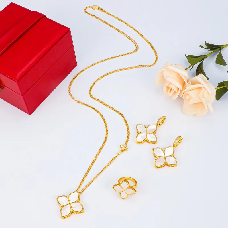Open-petal necklace & studs; gold tone, botanical design. Full-frame photograph with existing branding.