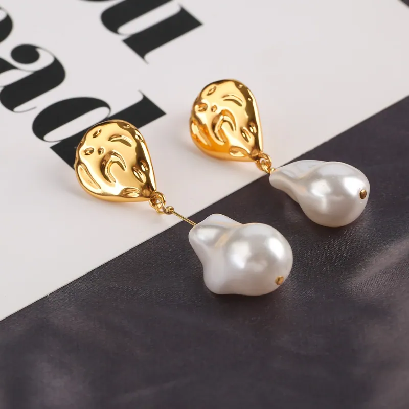 Sculpted pearl-look drops; gold tone, pearl accents design. Full-frame photograph with existing branding.