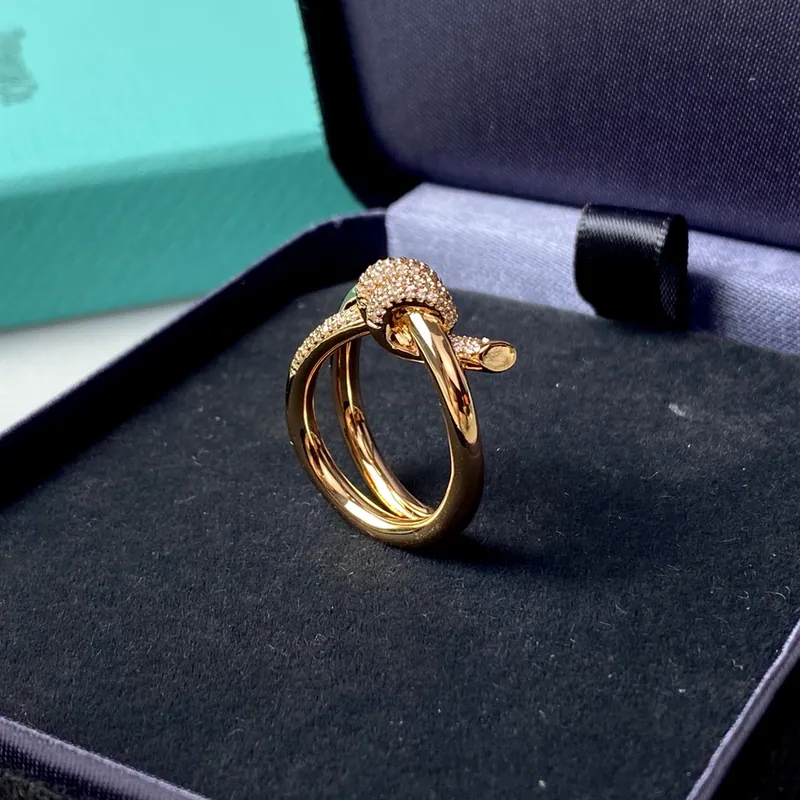Knotted double-band ring; gold tone, sculptural design. Full-frame photograph with existing branding.