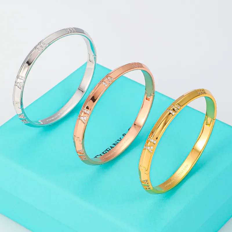 Roman-numeral bangles; mixed tones, sculptural design. Full-frame photograph with existing branding.